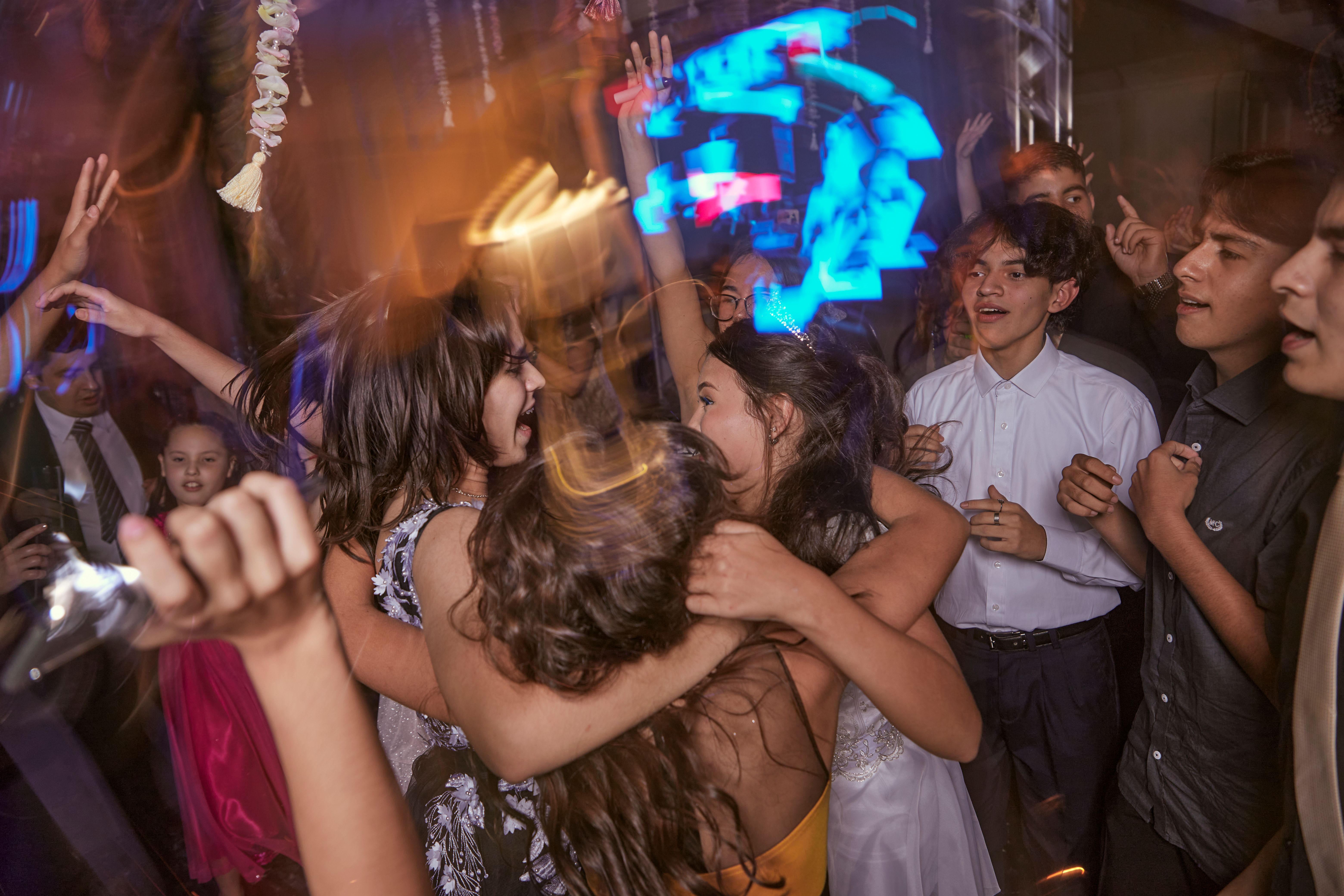 Jóvenes bailando en celebración con iluminación de color