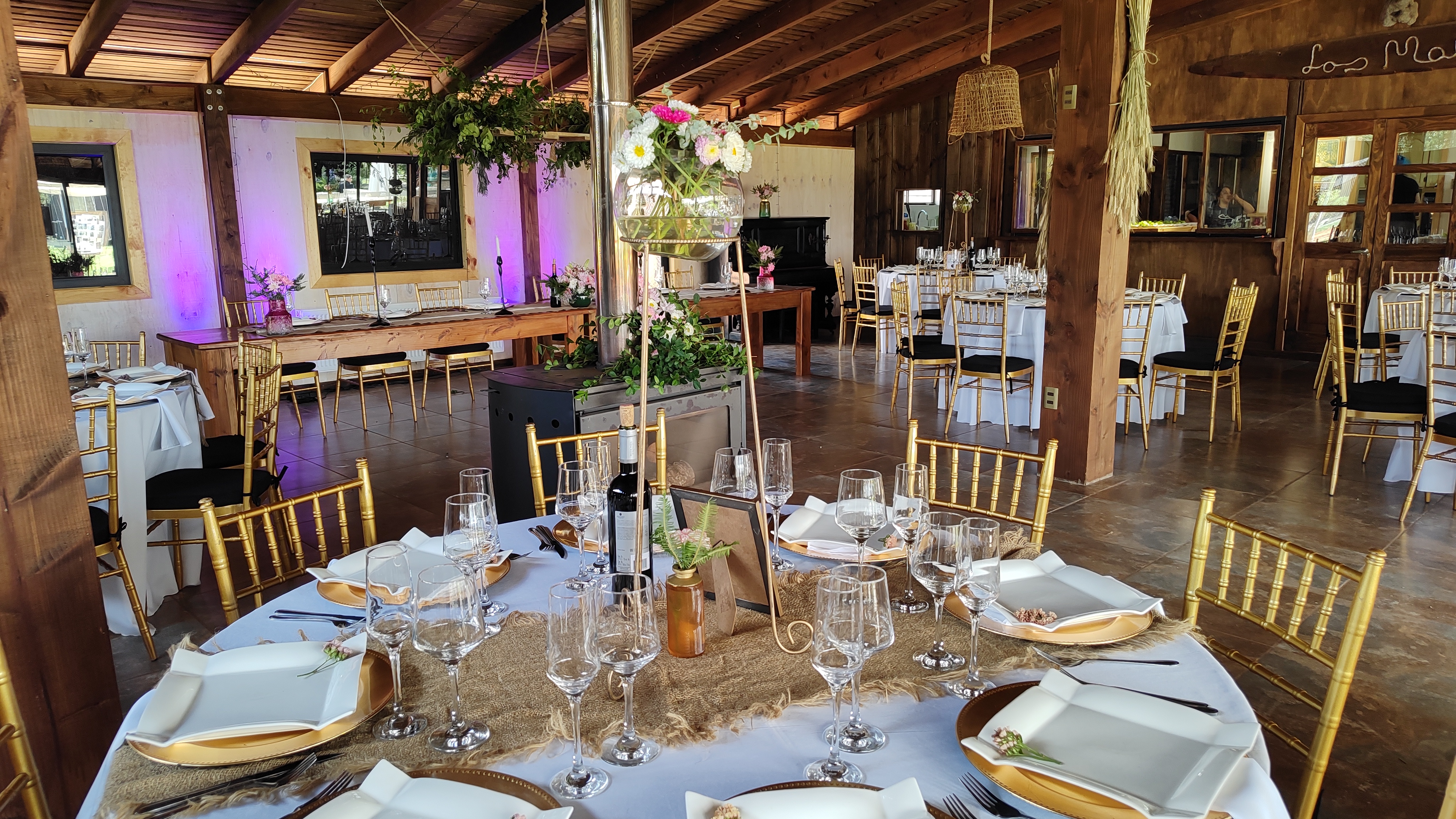 Montaje elegante de mesa con copas en salón rústico de madera
