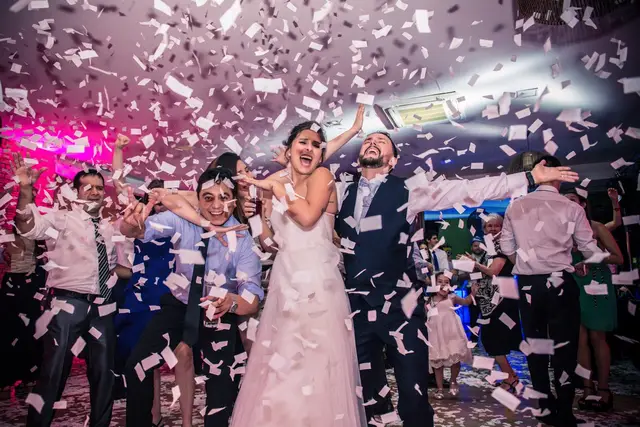 Novios celebrando con lluvia de confeti en la pista