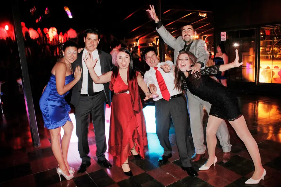 Grupo de invitados posando en la pista de baile iluminada